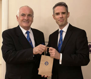 Patrick (left) presents traditional Eccles cakes to David.