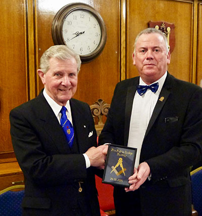 Stuart Thornber (left) receives a framed embroidered square and compasses from Juan Topping. Stuart Thornber (left) receives a framed embroidered square and compasses from Juan Topping.