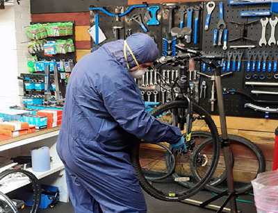 A Bike Works engineer in full PPE restoring a bike. A Bike Works engineer in full PPE restoring a bike.