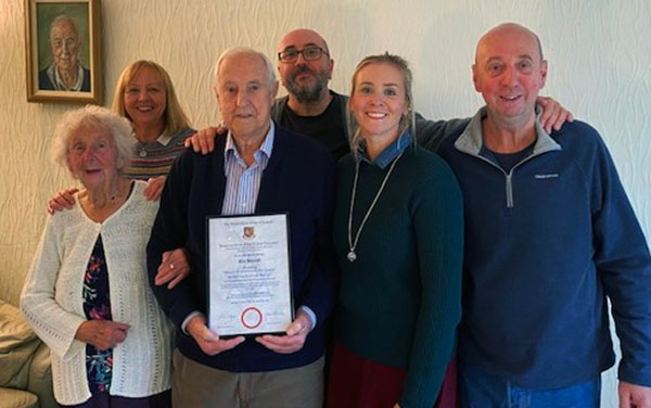 Eric proudly shows his certificate next to wife Win, with their daughter, two sons and granddaughter. 