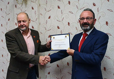 John Cross (left) presents Paul Smedley with his certificate.