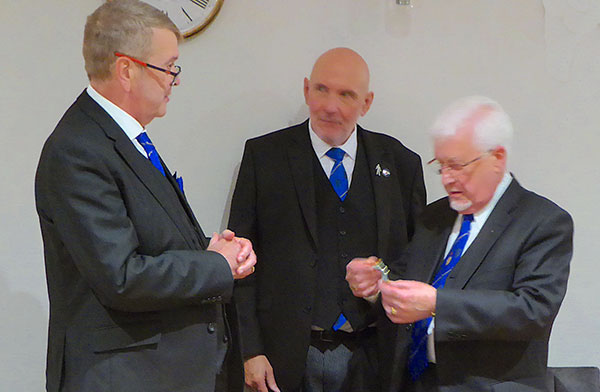 Gary (left) presents Eric Carroll with his jewel watched by director of ceremonies Phil Lyons.