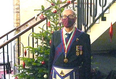 Masked-up John by the Christmas tree – perhaps the mask was to prevent him from singing!