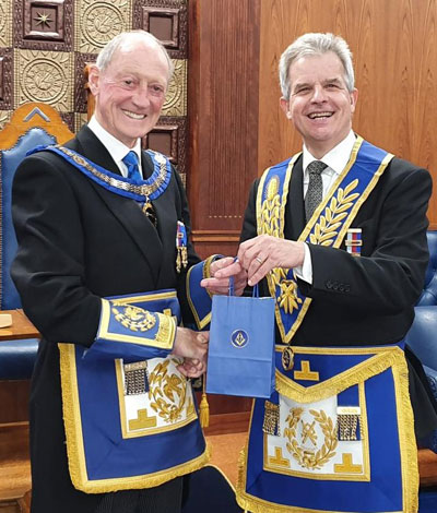 Stuart Boyd Group Chairman (right) presents Barry Jameson APGM with the traditional bag of Eccles cakes.