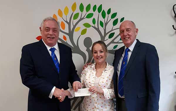 Derek Robinson presenting a cheque to Dionne Doherty of the Complete Kindness Café, accompanied by Derek Bond.