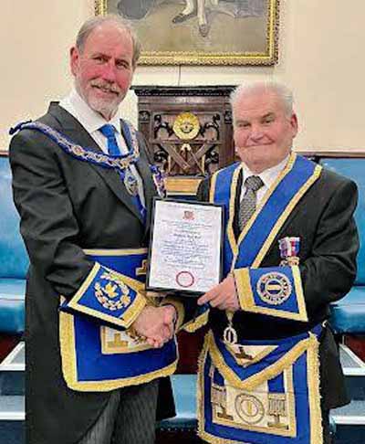 Frank Umbers (left) presents Roy Bell with his certificate.