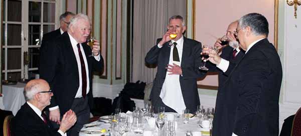 The three principals take wine with Paul (left).