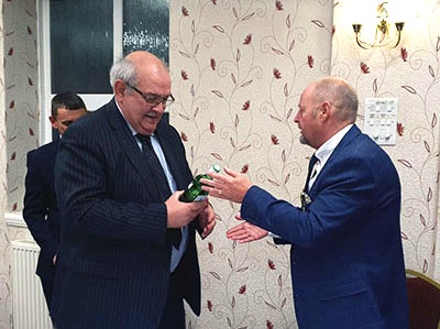 John Cross (right) presents Philip Gunning with a bottle of gin. John Cross (right) presents Philip Gunning with a bottle of gin.