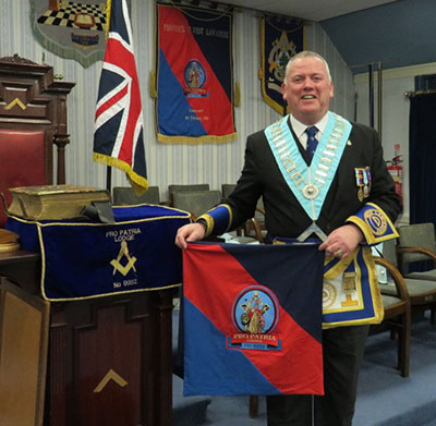 Juan Topping with the lodge’s miniature banner. 