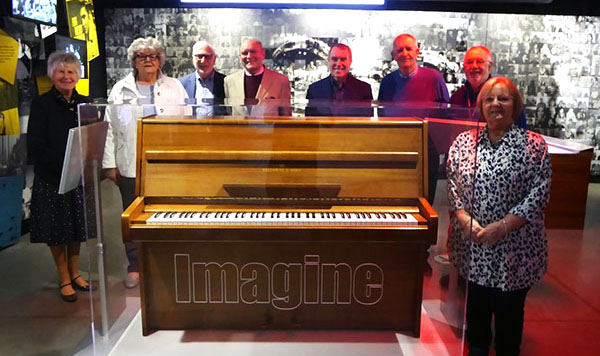 The group gather round the ‘Imagine’ piano.
