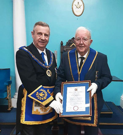 Winston (right) proudly shows Peter his certificate.