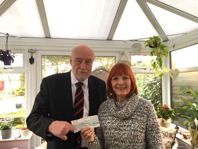 Derek presents a cheque to Karen Rainford, founder of Miles of Smiles.