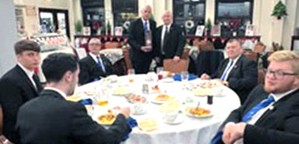Visiting brethren of Lathom Abbey Lodge tuck into their curry, while standing centre, Mike Trigg (left) of Aughton Lodge presents the ‘’travelling gavel’ to Phil Stansbie of Lathom Abbey Lodge.