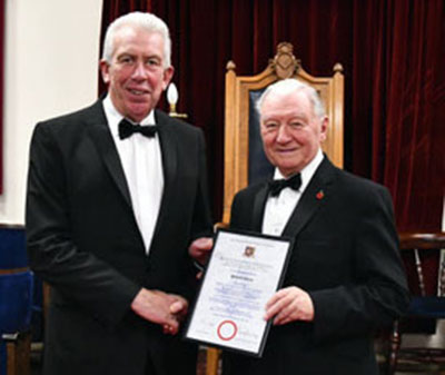 Howard Jones being presented with his certificate by Mark Matthews.