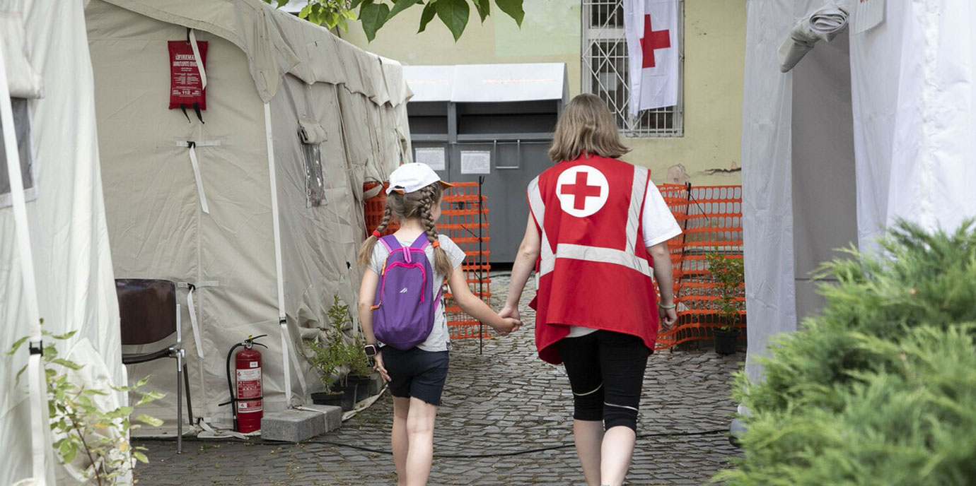 A Red Cross worker accompanies a child at the Red Cross Health Centre in Uzhhorod, western Ukraine. A Red Cross worker accompanies a child at the Red Cross Health Centre in Uzhhorod, western Ukraine.