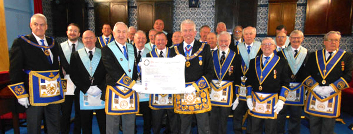 Andrew Whittle (left) with Ken Bradley with Mark Matthews (central) and the members of the lodge of Harmony.