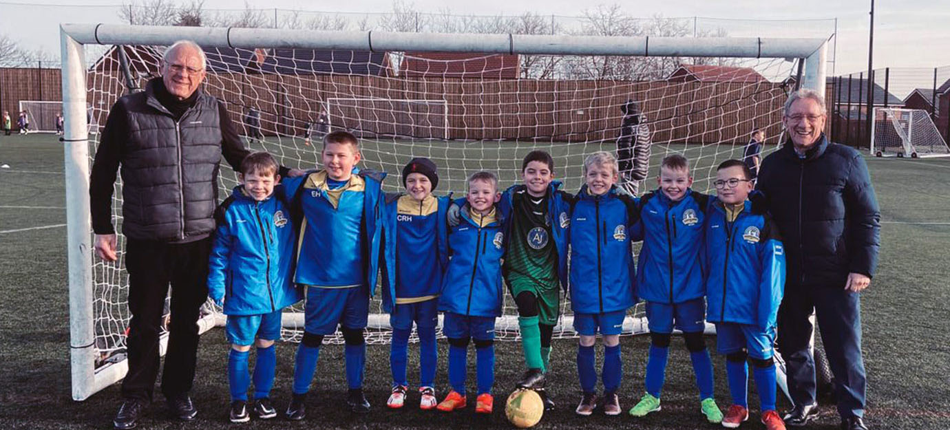 Mike Trigg (left) and Malcolm Sandywell with the team members, each proudly sporting their sponsored coats. Mike Trigg (left) and Malcolm Sandywell with the team members, each proudly sporting their sponsored coats.