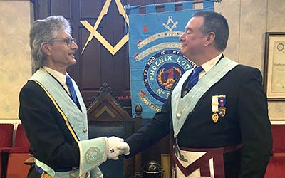 Newly-installed master Stephen Grimshaw (left) being congratulated by Chris Jones.