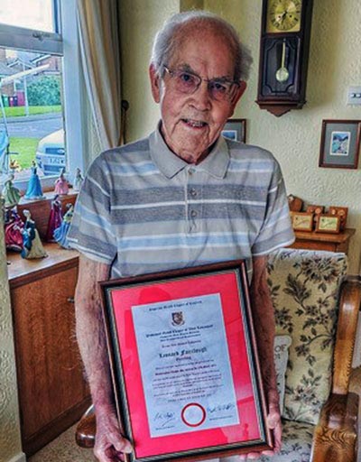 Leonard at home proudly holding the framed certificate commemorating his 50 years in Royal Arch Freemasonry.