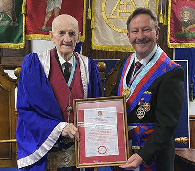 Allan Scott (left) receiving his certificate from Paul Hesketh.