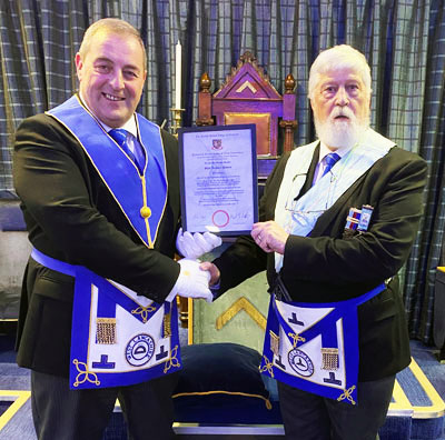Scott Devine (left) presenting Glyn Davies with his certificate.