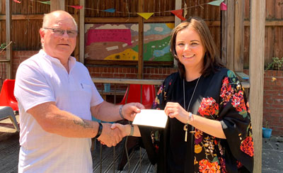 Cliff Jones presents a cheque to Faye Atherton of Young Carers.