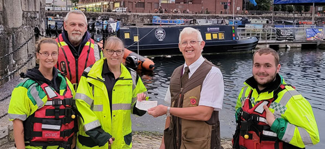 Merseyside Water Rescue receiving a £1,050 cheque from the WLMCPSS on the waterfront. Pictured from left to right, are: Charlotte Broughton (team member), Ian Milburn (founder and trustee), Ruth Milburn (treasurer and fundraiser), John Bruffell and Ryan Barnes (team member).