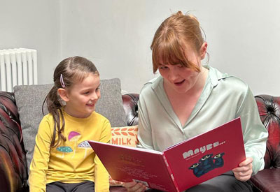 A volunteer from The Reader engaged in a reading session.