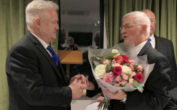 Tommy Lunt presents flowers to Peter Schofield