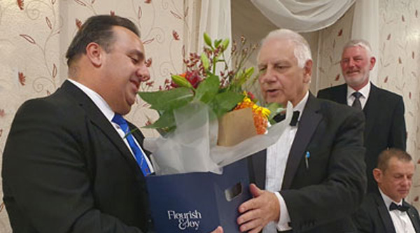 Michael Tax (left) is presented with flowers by Frank Howarth.