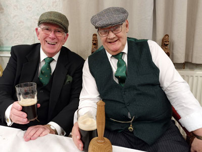 Tony Harrison (left) and Mike Casey share ‘flat cap gags’ at the festive board.