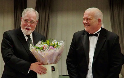 Philip Gardner (left) thanking Hughie Nelson for the gift of flowers.