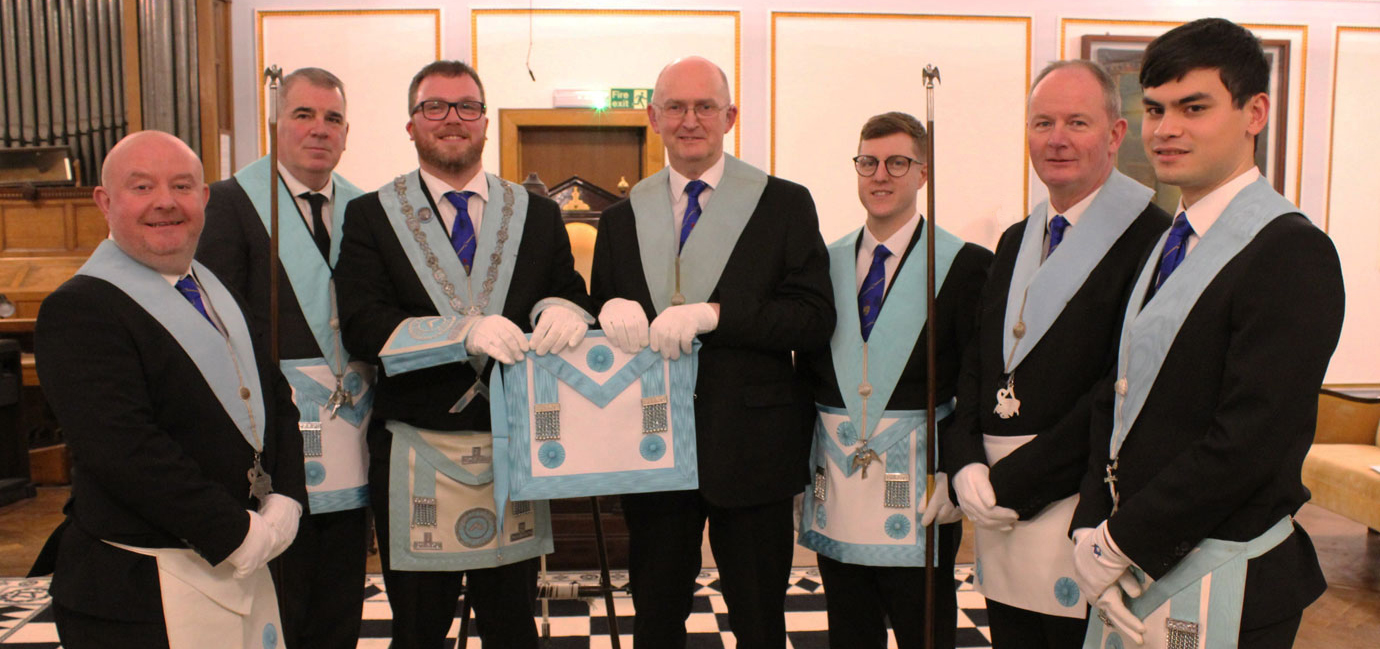 Pictured from left to right, are: Peter Grihault, Darren Collins (SD), Will Buchanan Jnr (presenting his father with a master Masons apron), William Buchanan Snr, Jordan Brown (JD), Dave Eastwood and Ben Nicholas