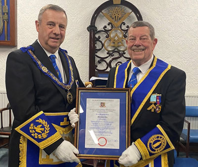 Peter Lockett (left) presenting Norman Cox with his 50 years in Freemasonry certificate.