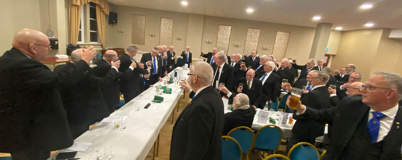 Brethren toasting to the health of Norman Cox at his 50th celebration.