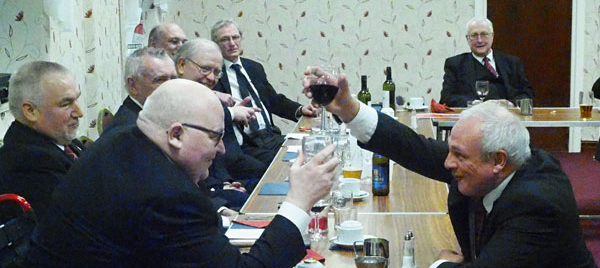 John Darrell (kneeling right) takes wine with Joe O’Brien during the Principal’s Song
