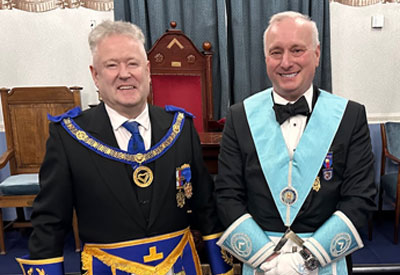 Assistant Provincial Grand Master Peter Schofield congratulates David Makinson on attaining the chair