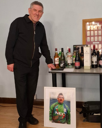 Peter Beardsley stands guard over the auction prizes. Peter Beardsley stands guard over the auction prizes.