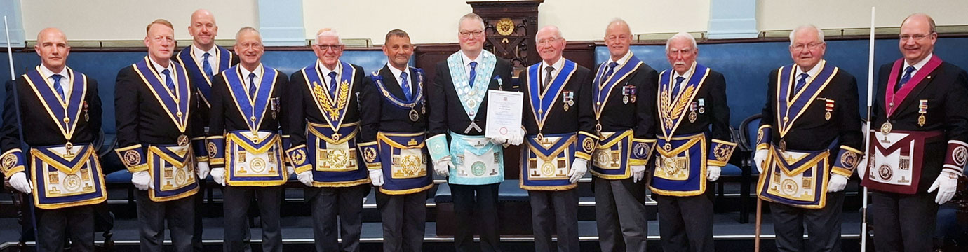 Geoff and Peter McPhail hold the certificate surrounded by esteemed guests. Geoff and Peter McPhail hold the certificate surrounded by esteemed guests.